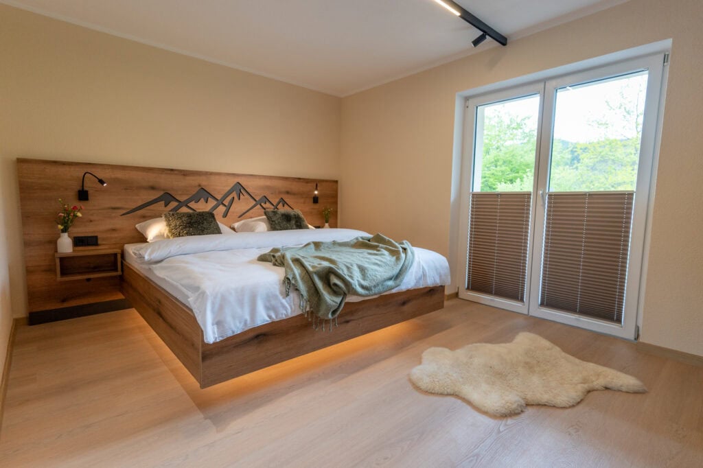 Gemütliches Schlafzimmer mit schwebendem Doppelbett in der Ferienwohnung in Ehrwald