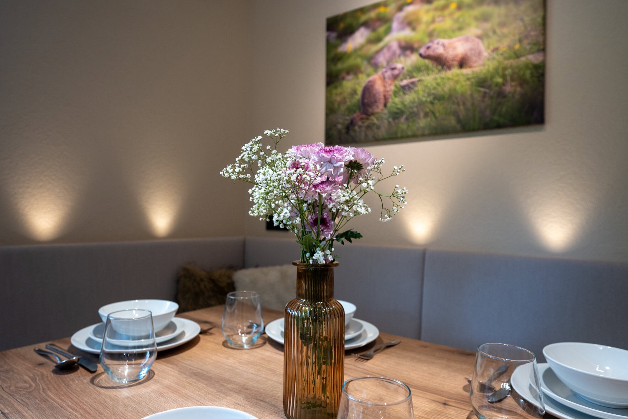 Dekorierter Esstisch mit Blumen und Geschirr in der Ferienwohnung Murmale.